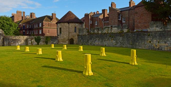 1) Foundation Myths comprises ten, life-sized, ceramic tree stumps arranged geometrically in two rows